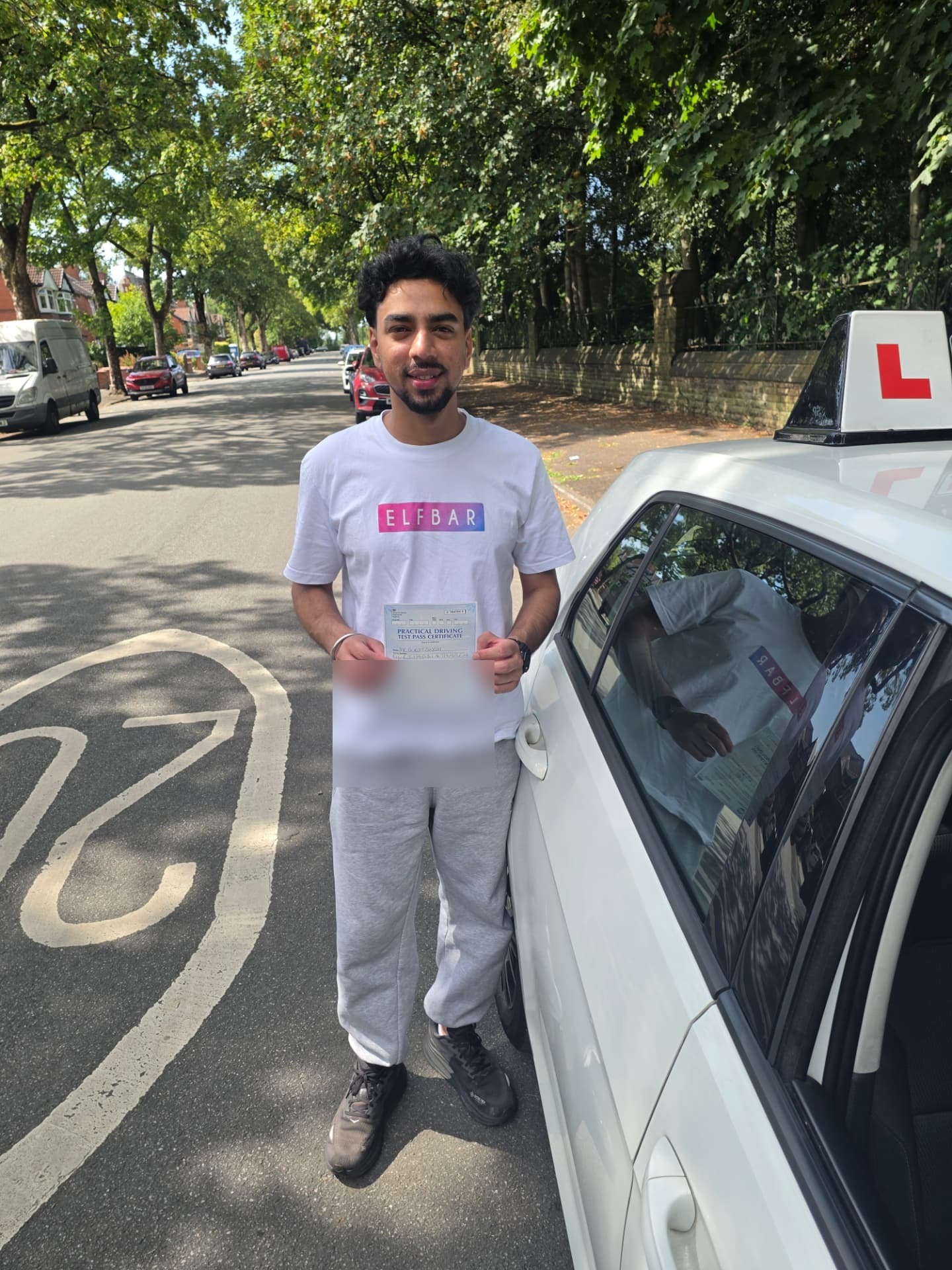 FSK Driving Instructors learner Gurjit holding his practical driving test pass certificate next to the learner car in Bury