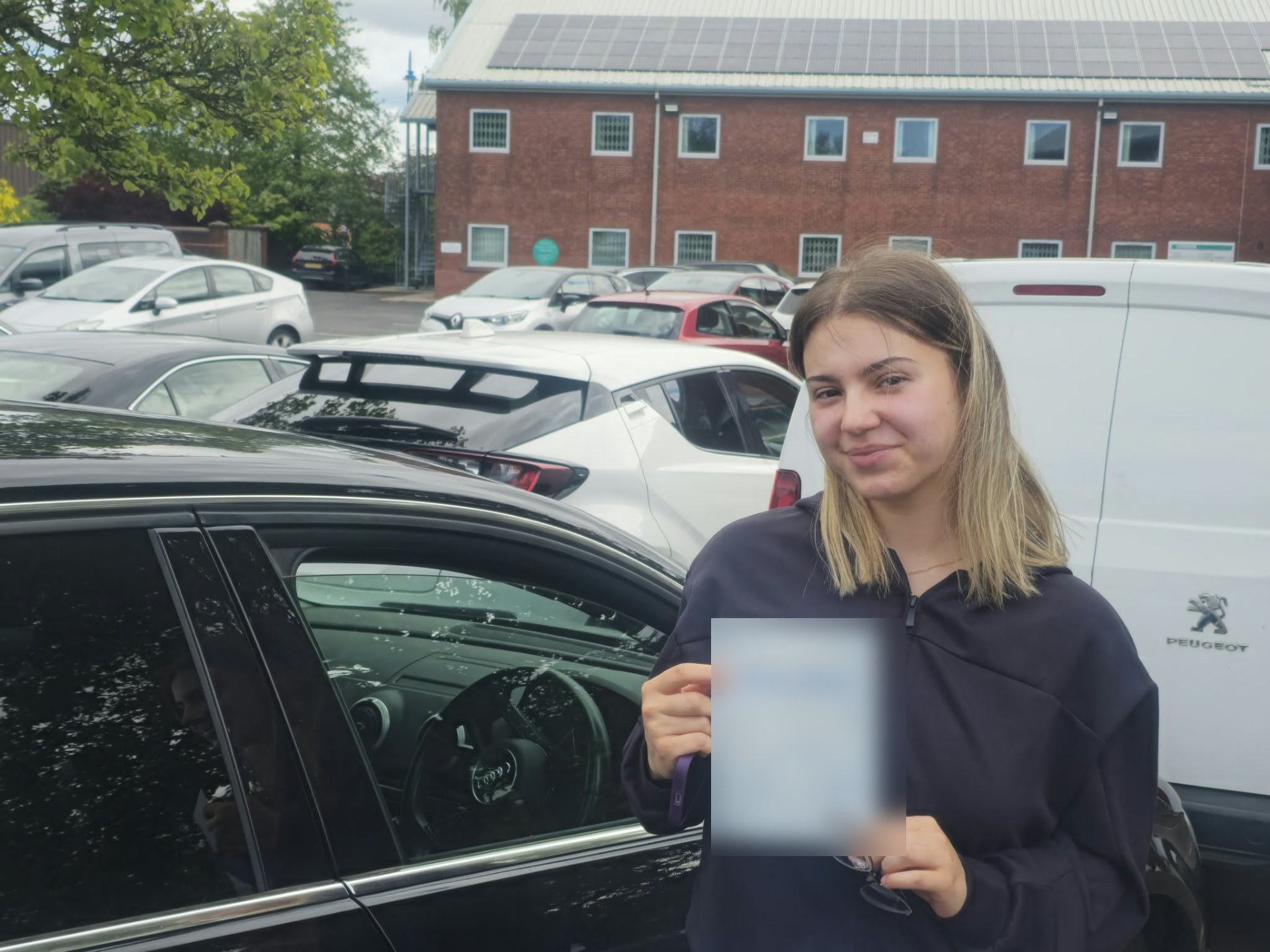 FSK Driving Instructors learner Monika holding her practical driving test pass certificate next to the learner car in Rochdale