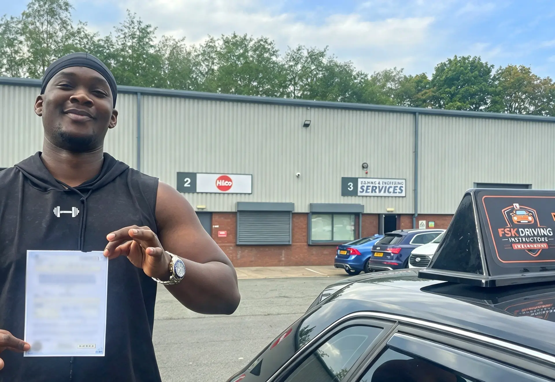 FSK Driving Instructors learner John holding his practical driving test pass certificate next to the FSK learner car after passing his driving test in Rochdale